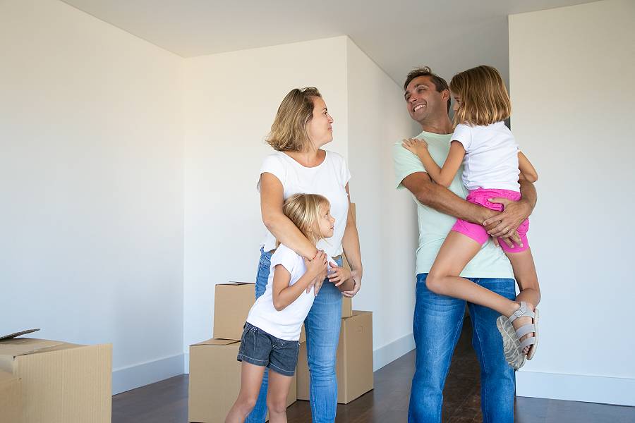 happy-parents-kids-enjoying-moving-into-new-flat-standing-near-stack-boxes-hugging (1).jpg
